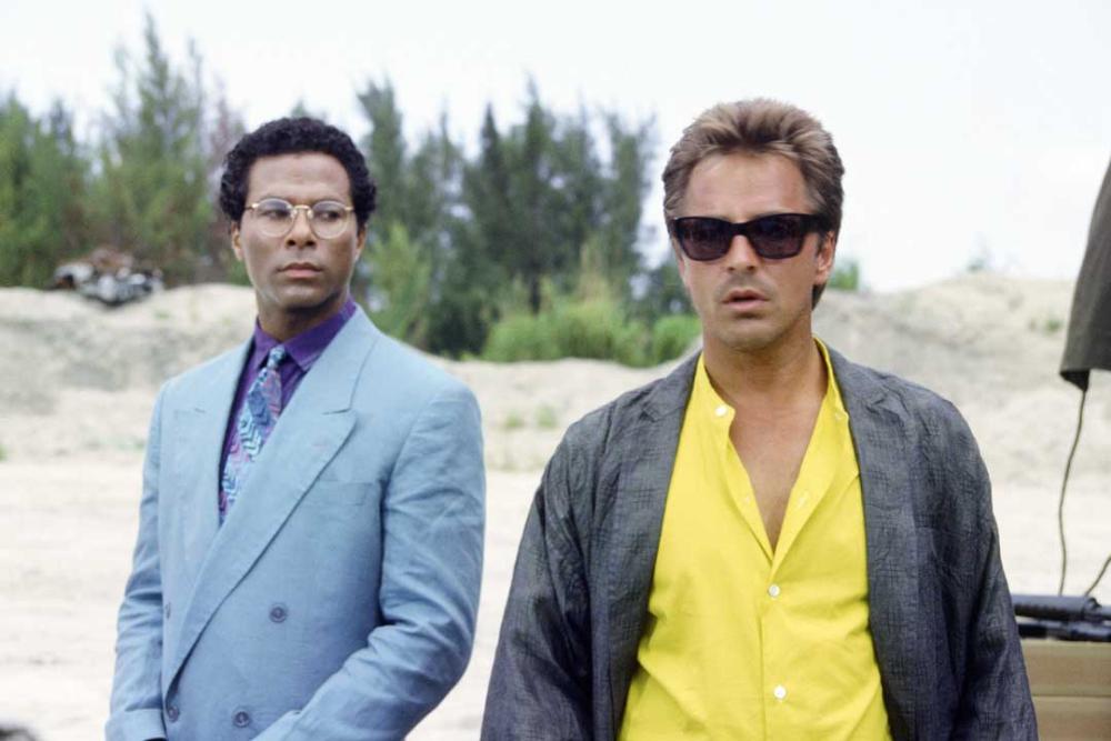 Sonny-from-Miami-Vice-wearing-black-Persol-Ratti-69218-sunglasses-frame-and-suit-standing-beside-his-partner-Rico-Tubbs.jpg